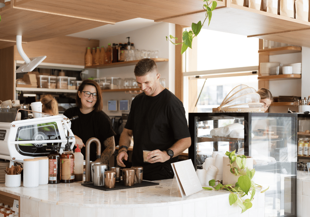 workers laughing and working in cafe